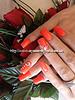 Acrylic nails with orange gel polish and Swarovski crystals on ring finger